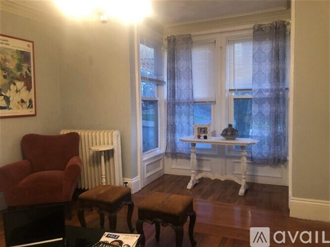 A living room with a red chair and a white table.