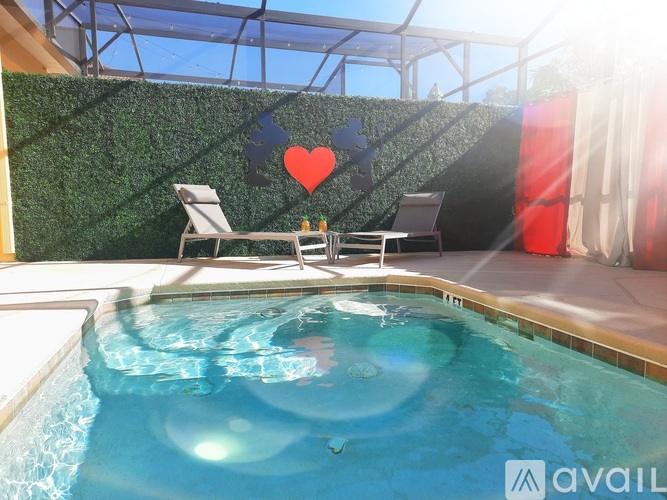 A pool with a green wall and a red heart hanging on it.