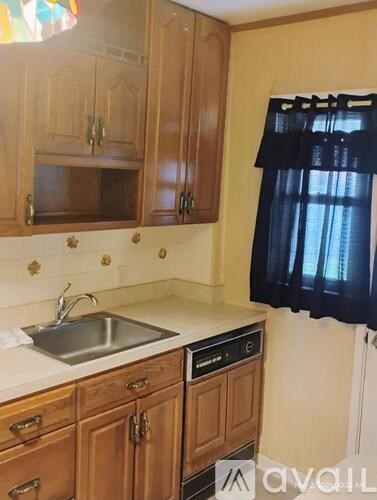 A kitchen with wooden cabinets and a stainless steel sink.