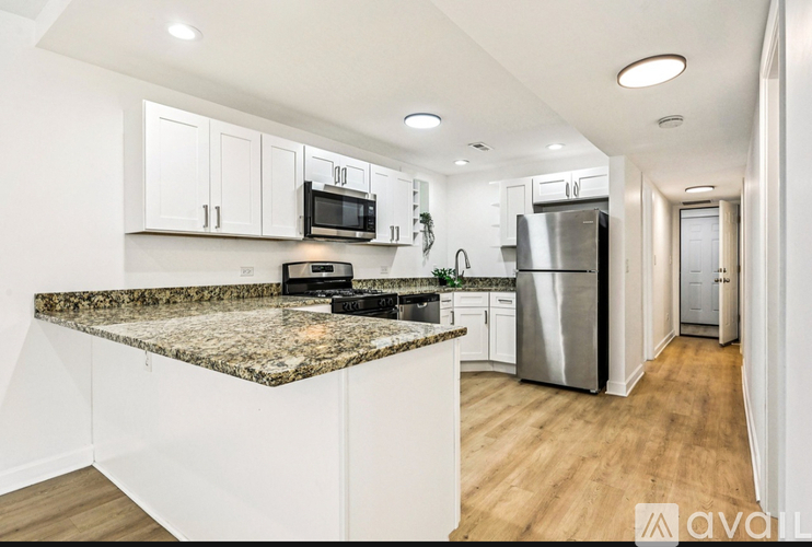 A kitchen with a granite countertop and stainless steel appliances.