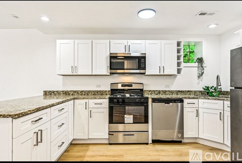 A kitchen with white cabinets and a granite countertop.