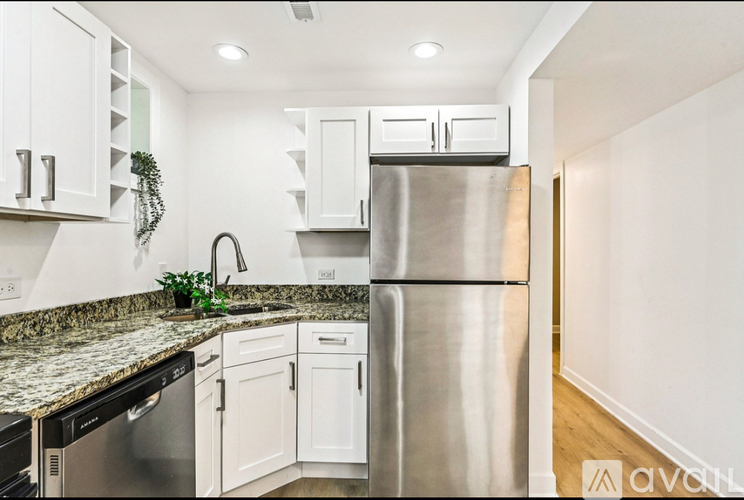 A kitchen with a granite countertop and stainless steel appliances.