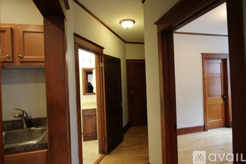 A kitchen area with a sink and wooden cabinets.