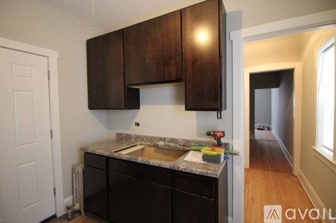 A kitchen with dark wood cabinets and a granite countertop.