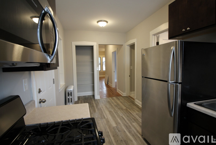 A modern kitchen with a stainless steel refrigerator and a black stove top.