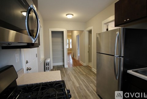 A modern kitchen with a stainless steel refrigerator and a black stove top.