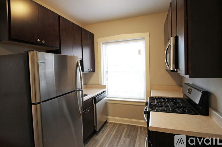 A kitchen with a stainless steel refrigerator and a stove top oven.