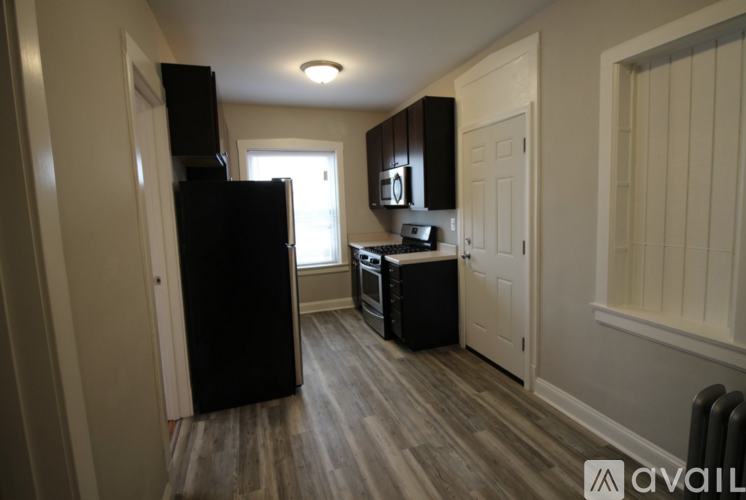 A kitchen with a black fridge, black microwave, and black oven.