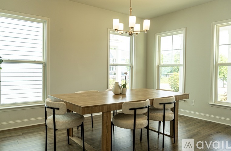 A dining room with a wooden table and chairs.