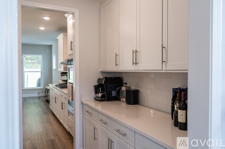 A kitchen with white cabinets and a white counter top.