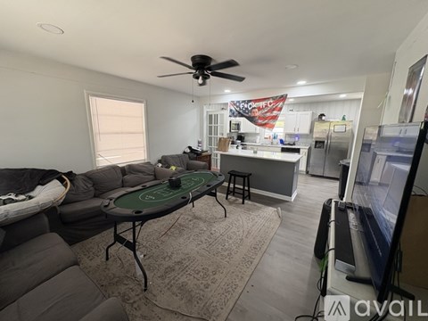 A living room with a pool table and a television.