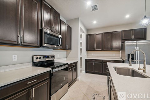A kitchen with brown cabinets and stainless steel appliances.