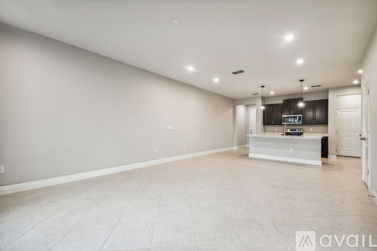 A spacious living room with a flat-screen TV and a cabinet.