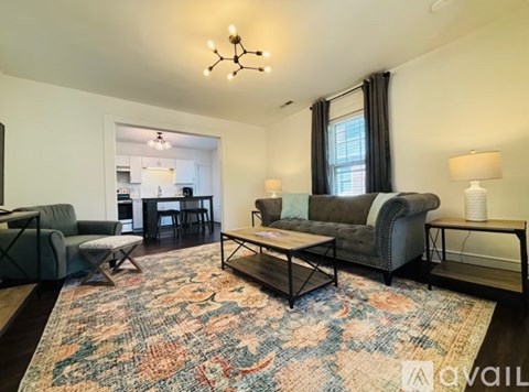 A living room with a grey couch, a coffee table, and a rug with a floral pattern.