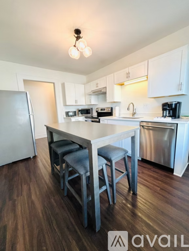 A kitchen with a table and chairs.