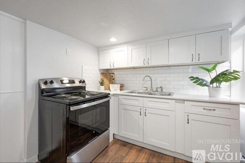 A kitchen with white cabinets and a black stove top oven.