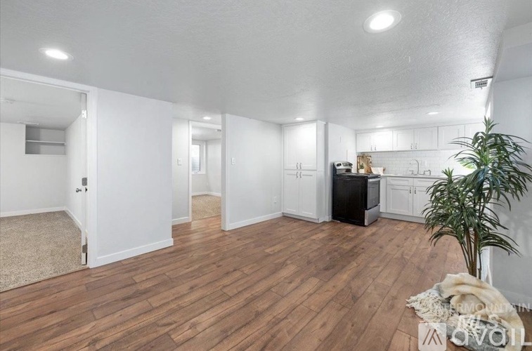 A living room with a wooden floor and white walls.
