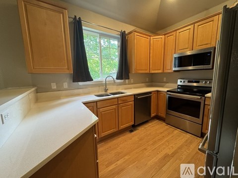 A kitchen with wooden cabinets and stainless steel appliances.