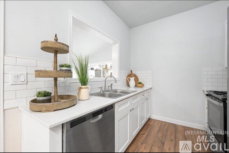 A kitchen with white cabinets and a wooden tray on the counter.