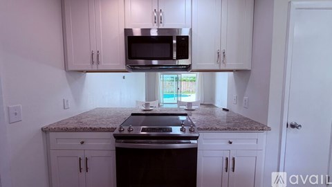 A kitchen with white cabinets and a granite countertop.