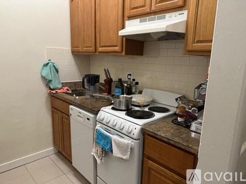 A kitchen with a white stove top oven and a white dishwasher.