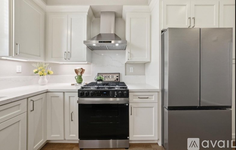 A kitchen with a stove and refrigerator.