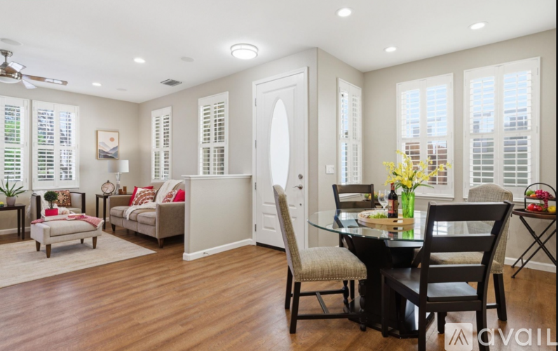 A well-lit dining room with a table set for two.