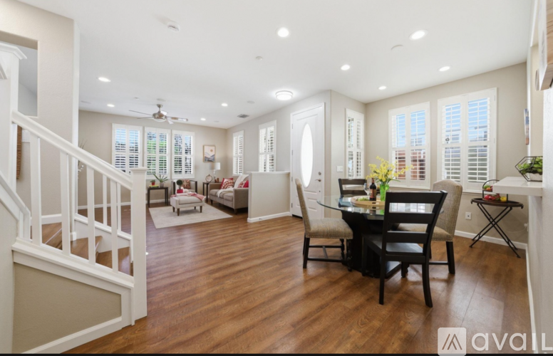A spacious living room with a dining table and chairs.