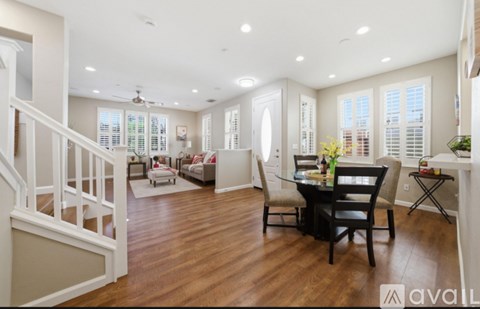 A spacious living room with a dining table and chairs.