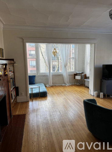 A living room with a black chair and a wooden floor.