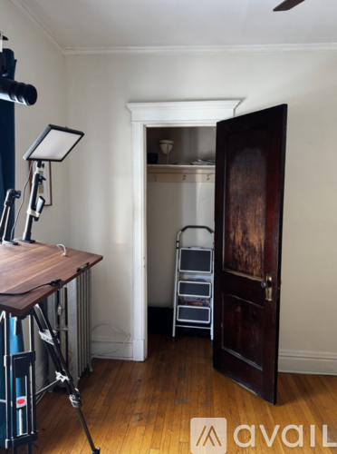 A room with a wooden floor and a door leading to another room.