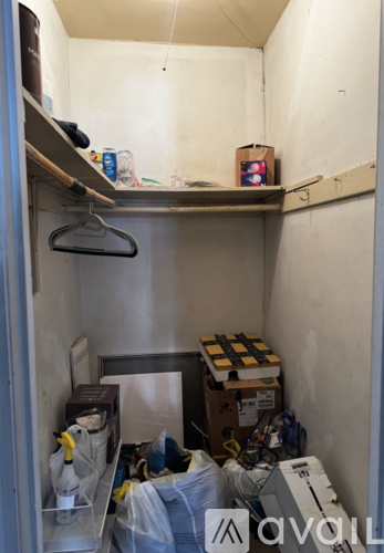 A small storage area with a hanger and various boxes.
