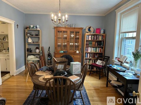 A dining room with a table set for four and a chandelier hanging from the ceiling.