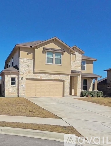 A beige house with a garage door and a driveway.