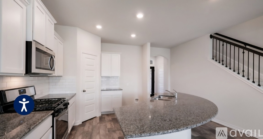 A kitchen with white cabinets and a granite countertop.