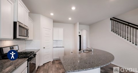 A kitchen with white cabinets and a granite countertop.