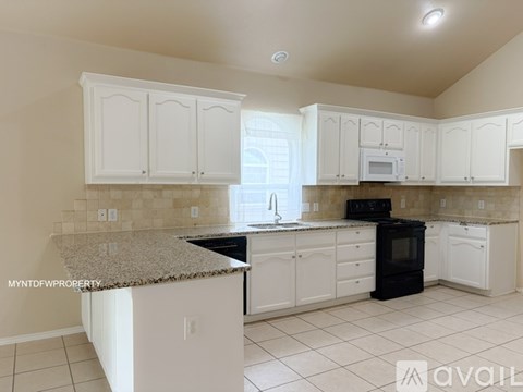 A kitchen with white cabinets and a granite countertop.