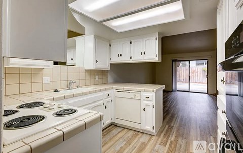 A kitchen with white appliances and cabinets.