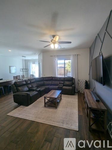 A living room with a black leather couch and a wooden coffee table.