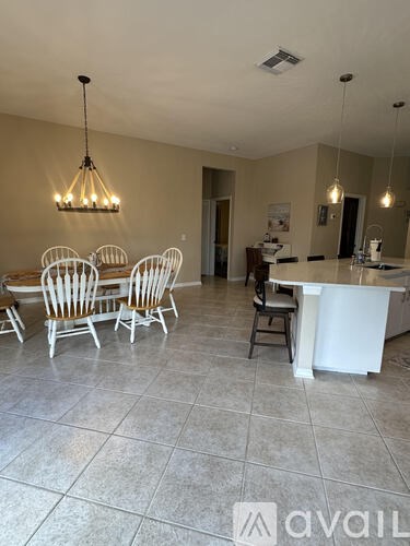 A kitchen with a dining table and chairs.