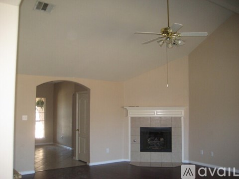 A living room with a fireplace and a ceiling fan.