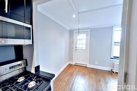 A kitchen with a black stove top oven and a white door.