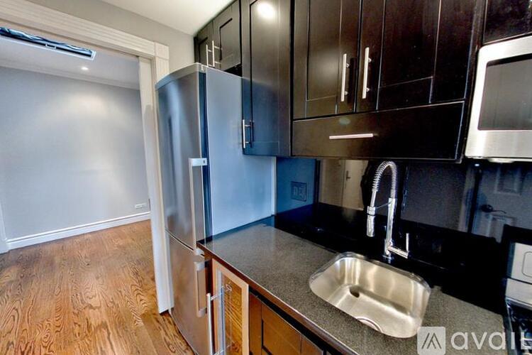 A kitchen with a sink and a refrigerator.