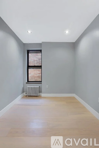 A spacious room with a radiator and a picture on the wall.