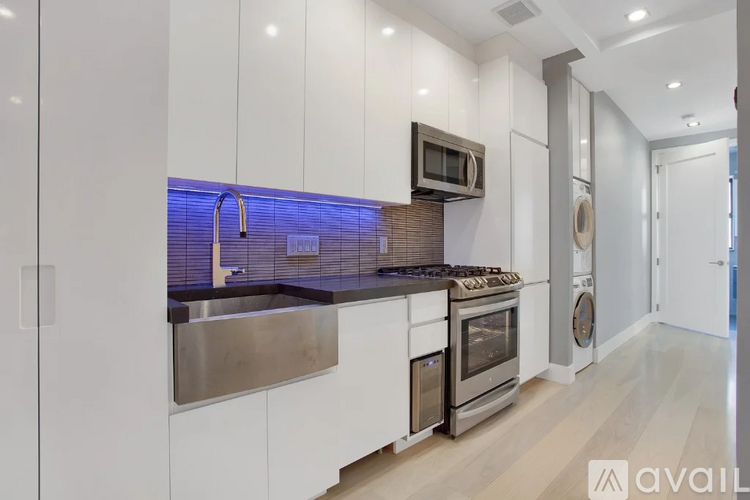 A modern kitchen with white cabinets and stainless steel appliances.
