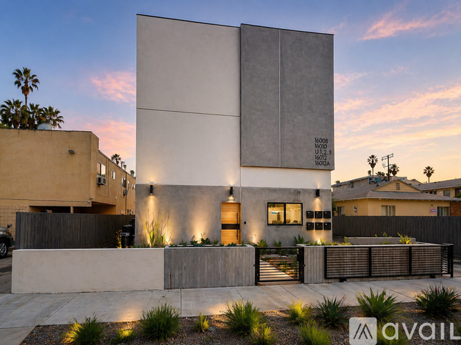 A modern house with a concrete exterior and a small garden in front.