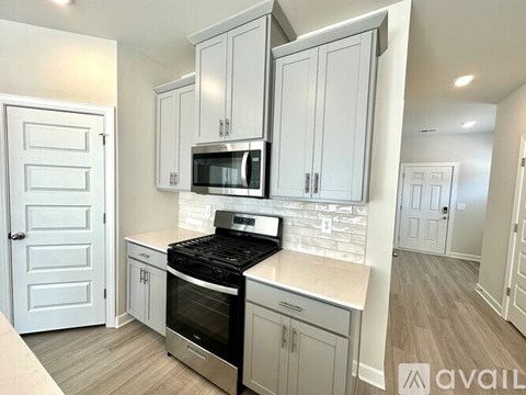 A kitchen with white cabinets and a black stove top oven.