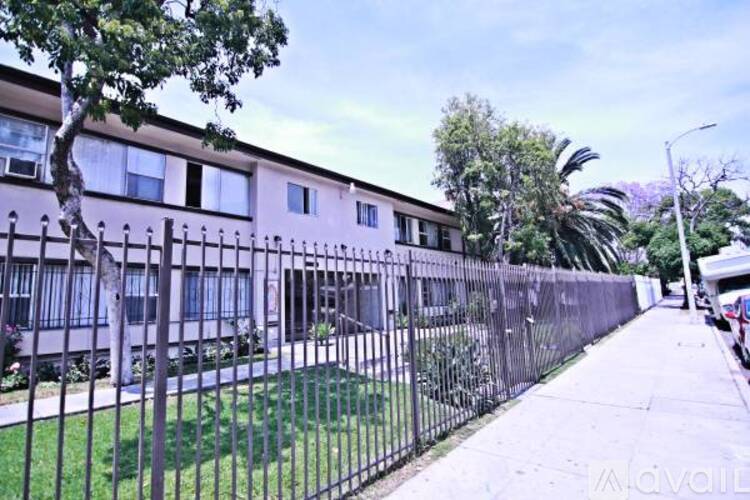 A long black fence runs along the side of a building.