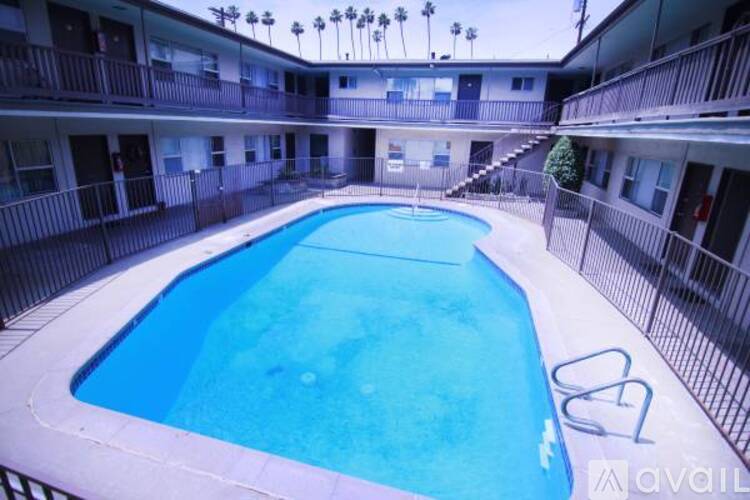 A pool in a courtyard surrounded by apartment buildings.