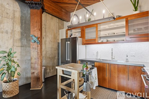 A kitchen with wooden cabinets and a black refrigerator.